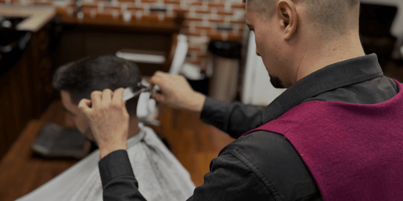 Barber care execută tunsoare fade din foarfecă